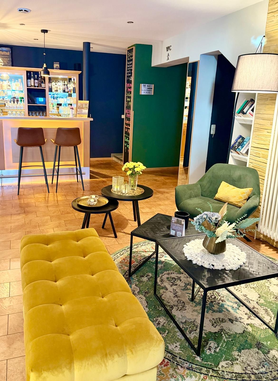 Blick auf Bar-Theke mit Barhockern und Lounge im Vordergrund