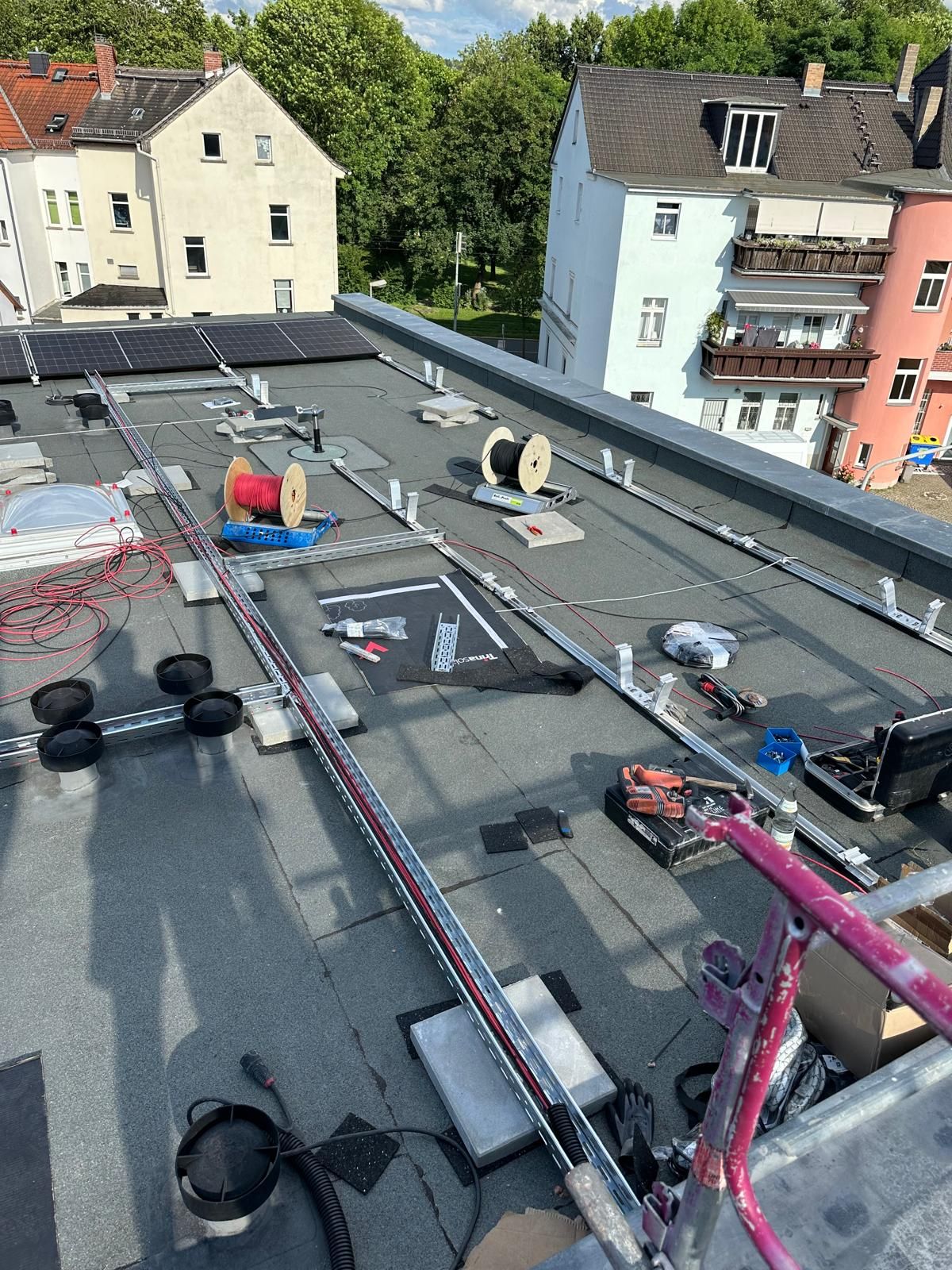 Leeres Dach des Hotels Gewürzmühle mit aufgestellten Kabeltrommeln vor Beginn der Photovoltaik-Montage