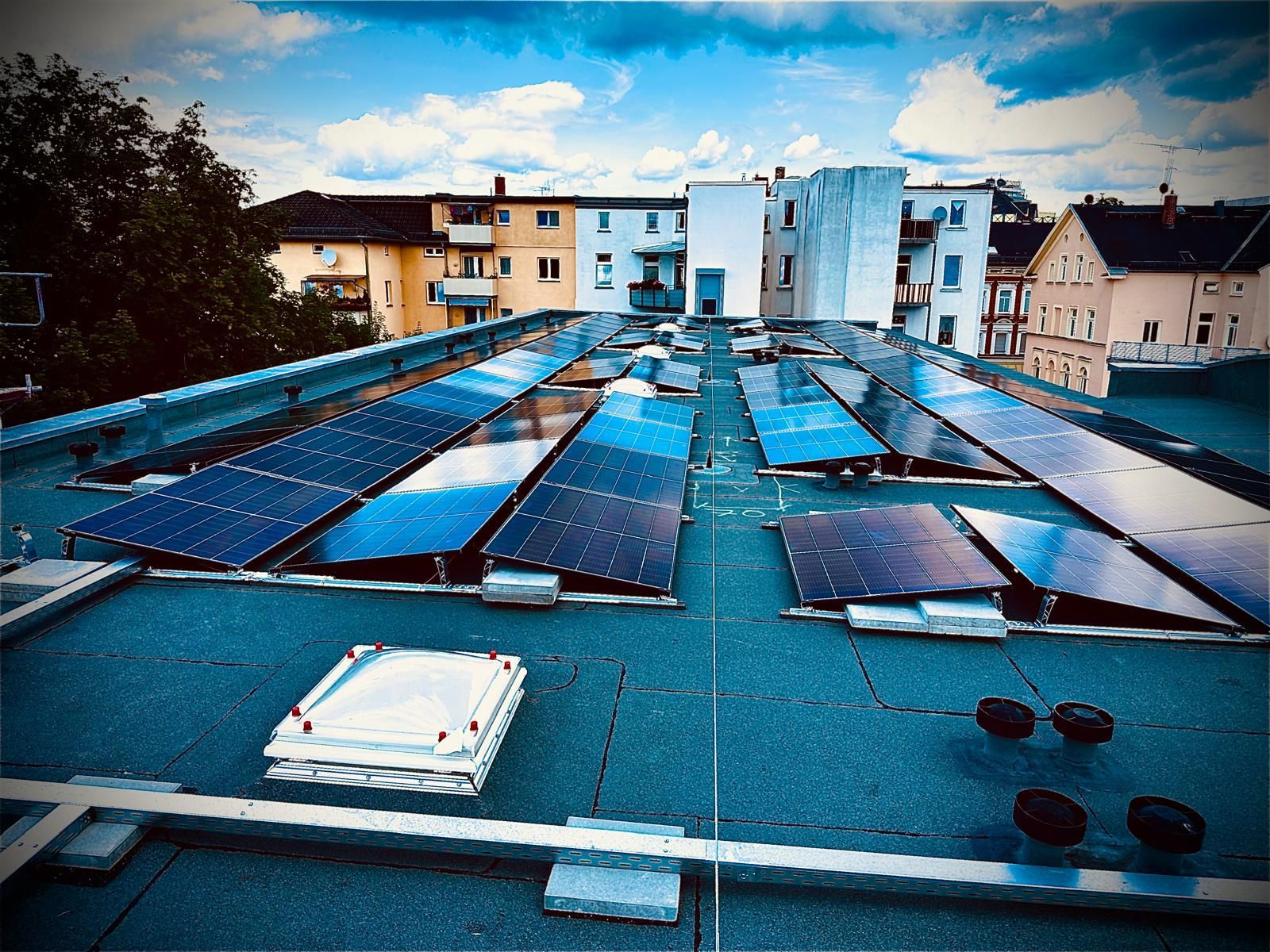 Detailaufnahme der Solar-Module mit Stadtblick im Hintergrund